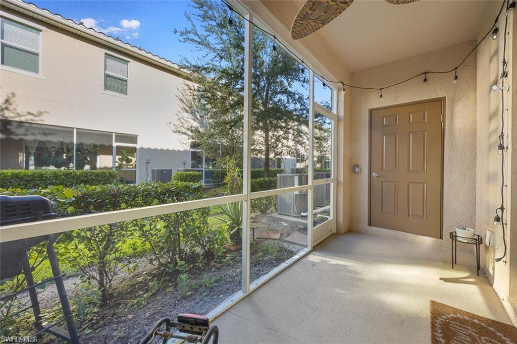 Screened outdoor patio featuring a textured concrete floor and a paneled door
