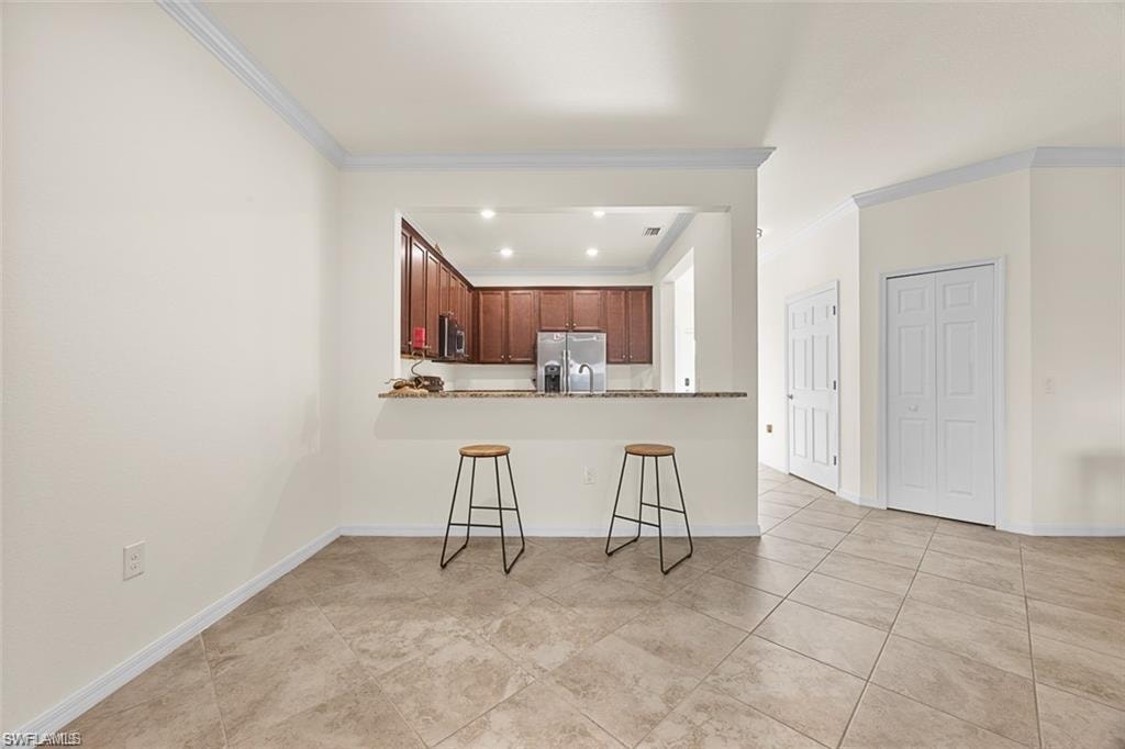 Kitchen pass-through with a stone countertop and wood cabinetry