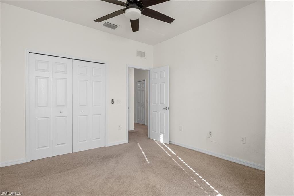Wall-to-wall carpeting, bi-fold closet doors, ceiling fan with integrated lighting, and a paneled interior door