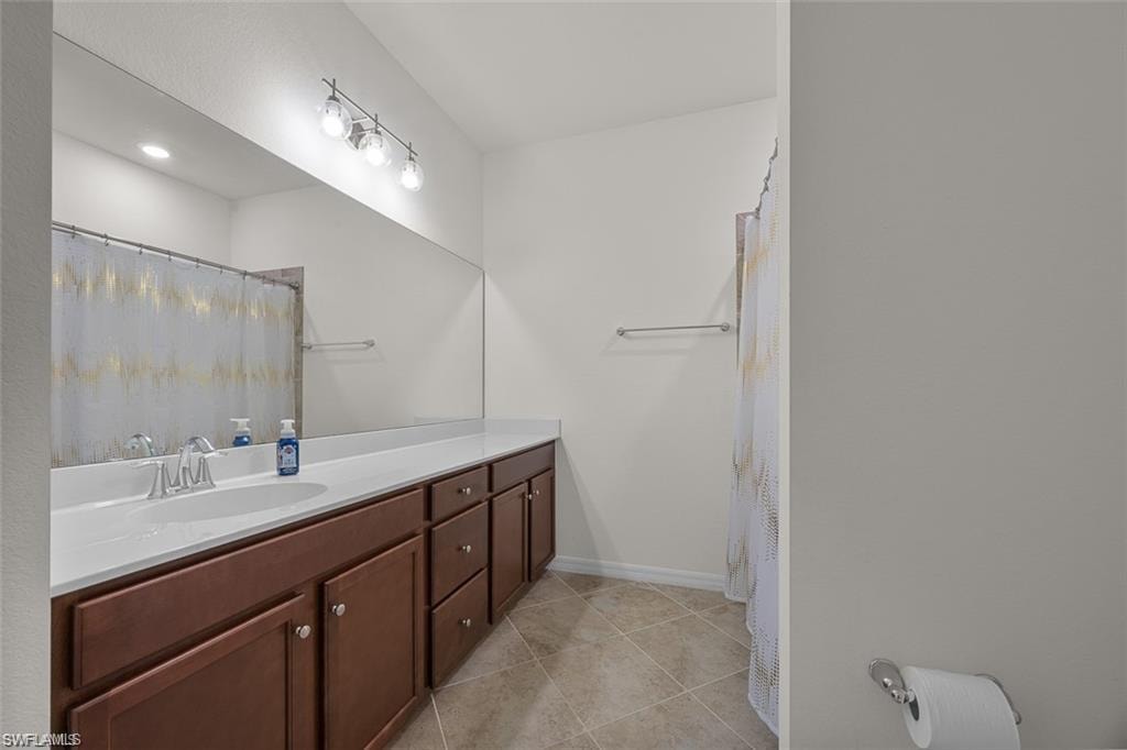 Dual vanity with wood-finish cabinetry, integrated sinks, and polished chrome fixtures