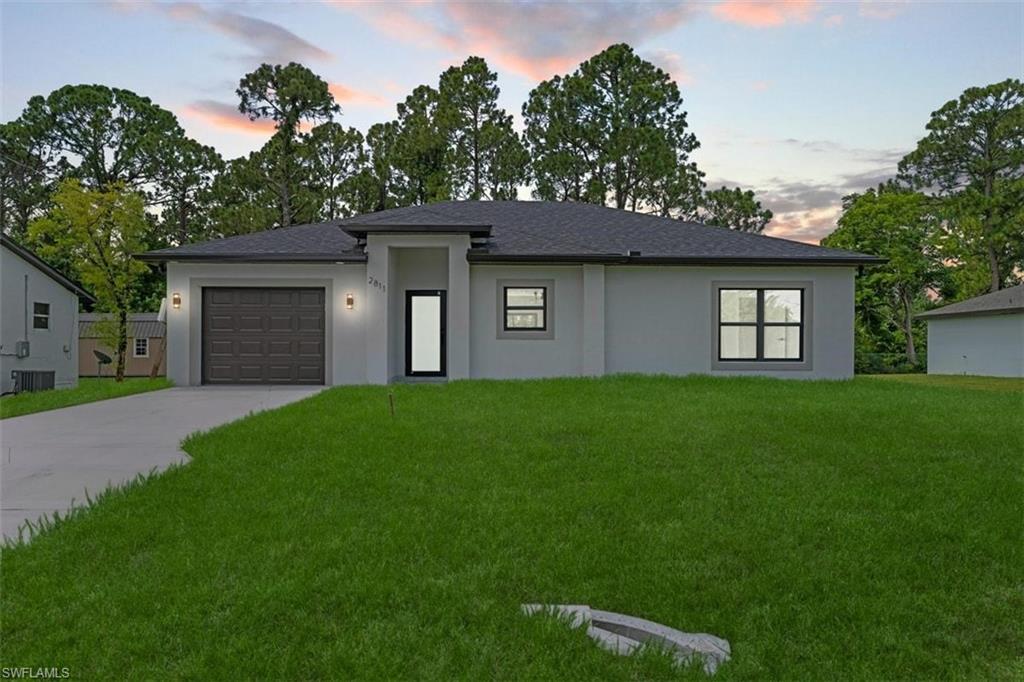 Contemporary stucco exterior with a dark shingle roof, integrated single-car garage, front entry with a full-light door, and a concrete driveway