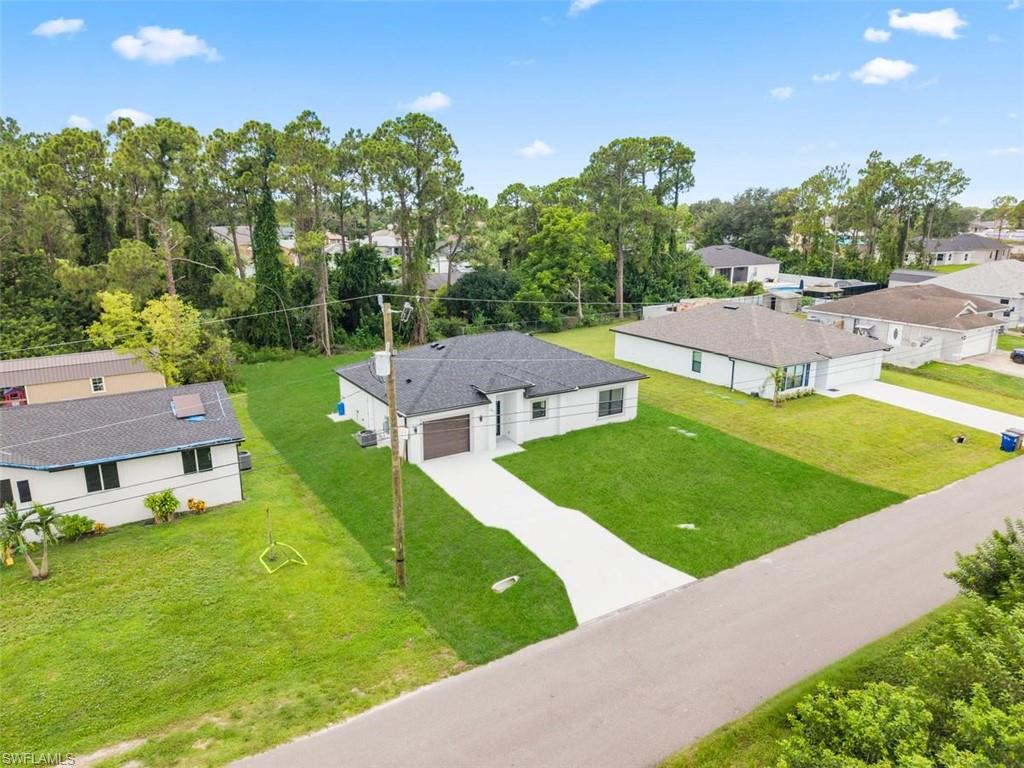 Single-story residence featuring a dark shingle roof, white exterior siding, and an attached garage with a wood-finish door