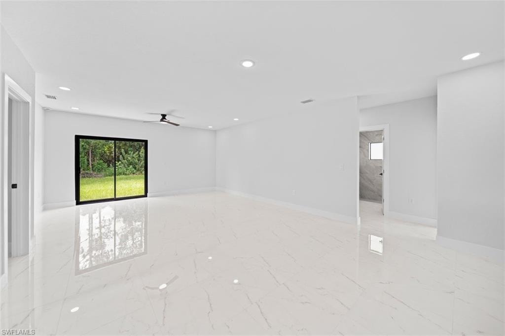 Spacious interior with large format porcelain tile flooring, recessed lighting, and a ceiling fan
