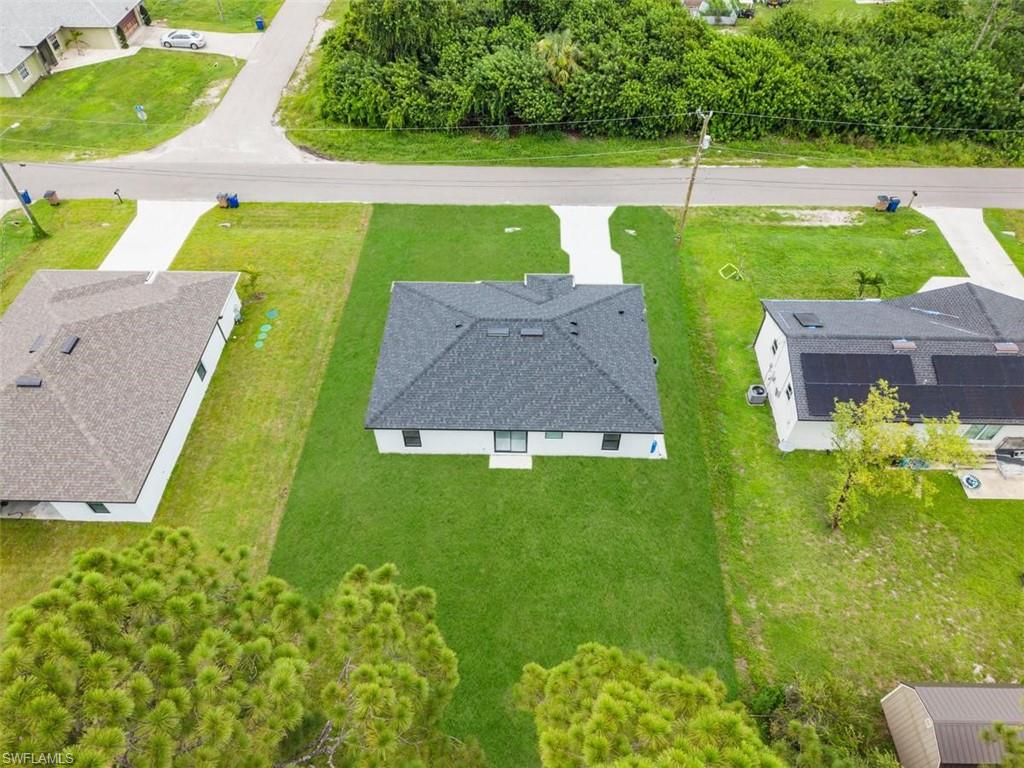 Pitched dark shingle roof, white exterior walls, and a light-colored driveway