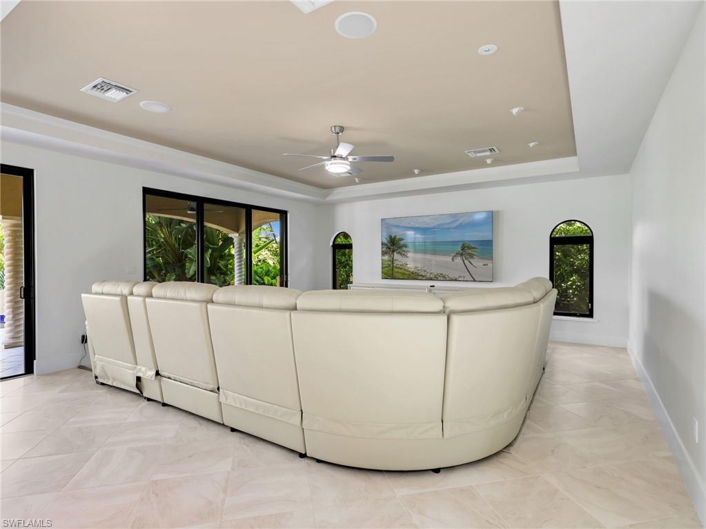 Recessed lighting, tray ceiling, ceiling fan, and large format tile flooring