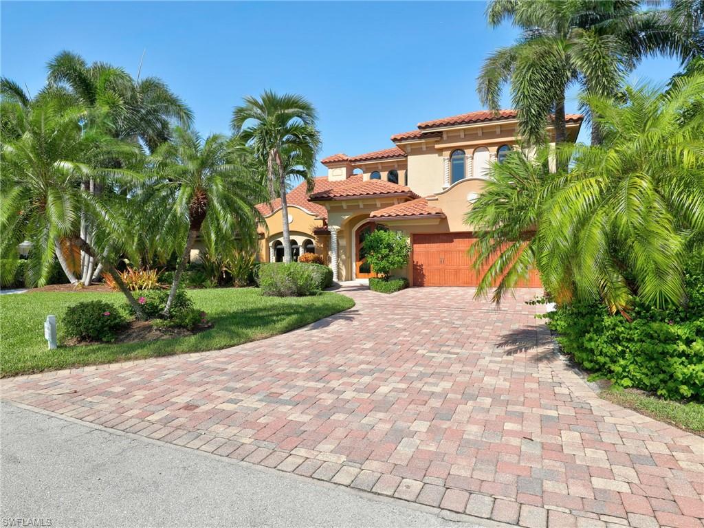 Spanish Colonial-style residence featuring a terracotta tile roof, arched entryways, and a warm stucco exterior