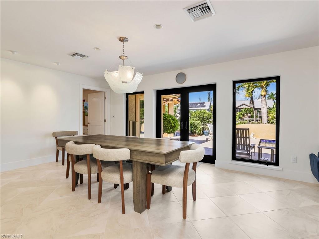 Recessed lighting, a decorative hanging fixture, and tile flooring
