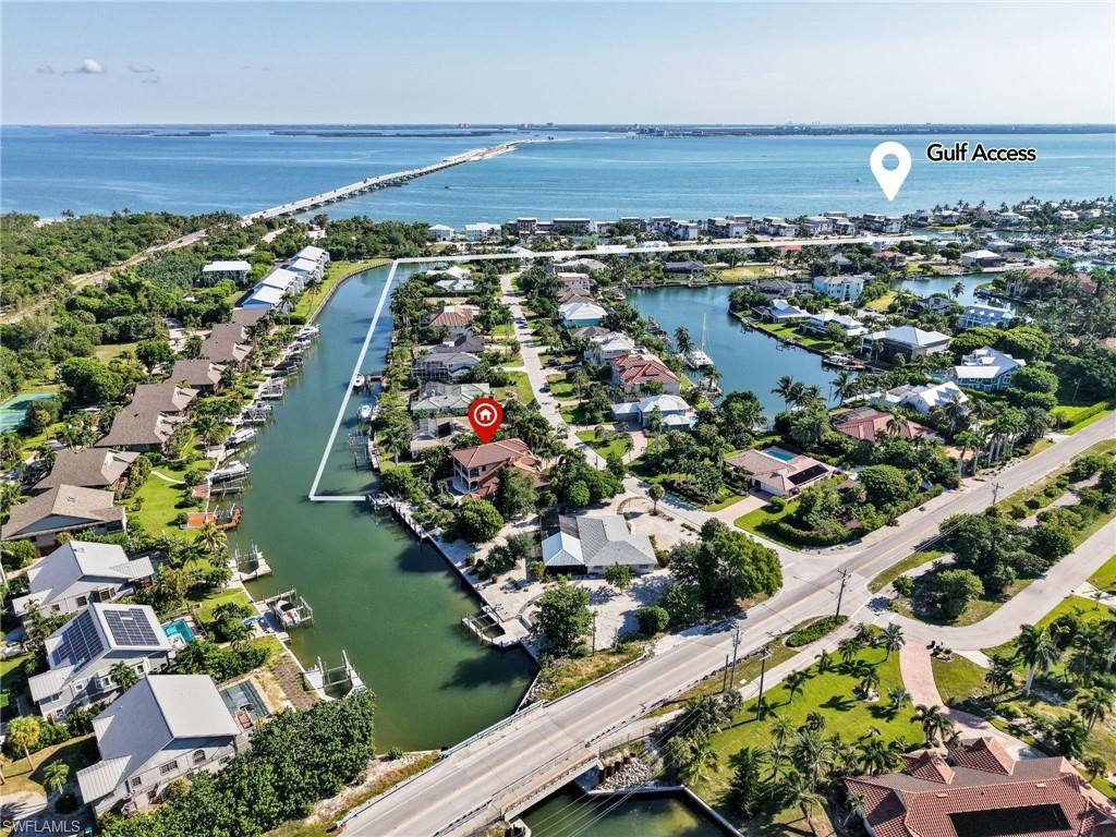 Waterfront residential area featuring a canal, a bridge, and distant body of water