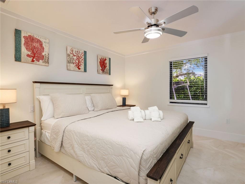 White walls, crown molding, and a ceiling fan with integrated lighting