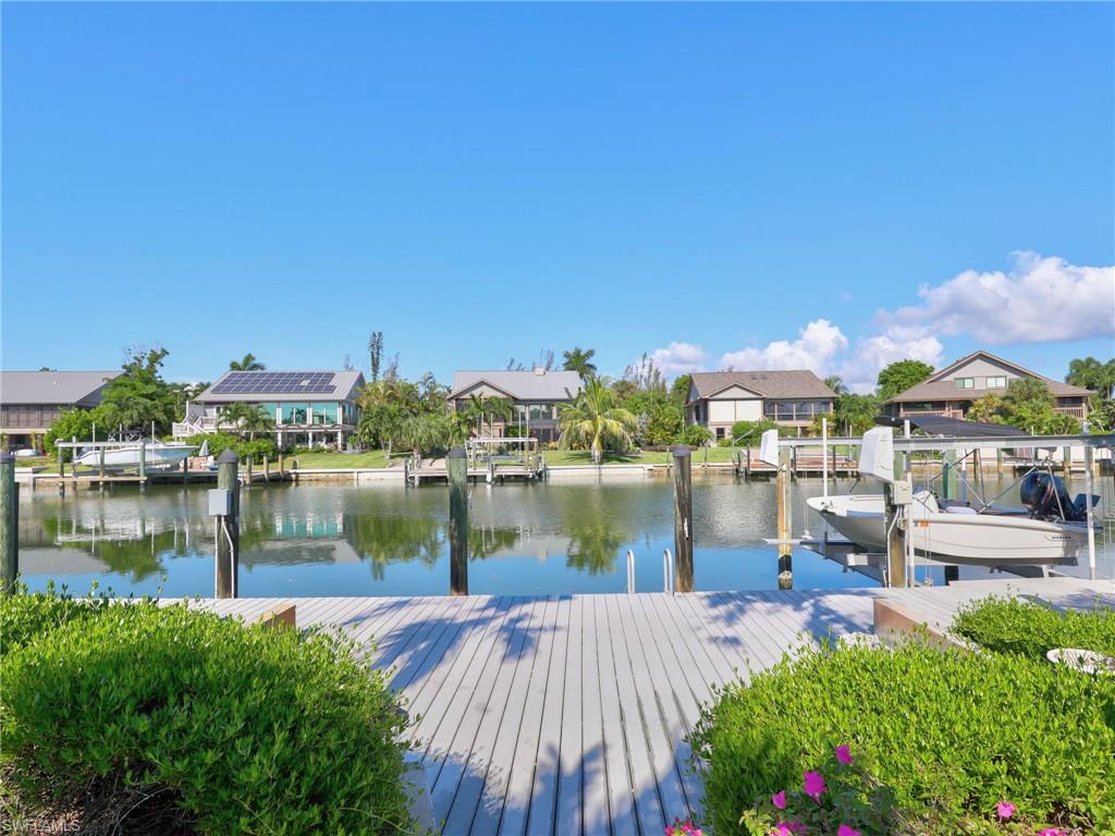 Waterfront residence featuring a composite deck overlooking a private boat dock and canal with direct water access