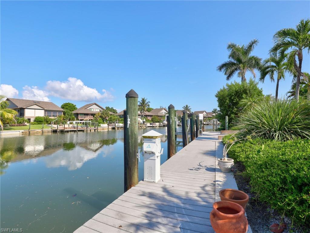 Private composite dock with wood decking and mooring posts extends into the waterfront, offering direct water access
