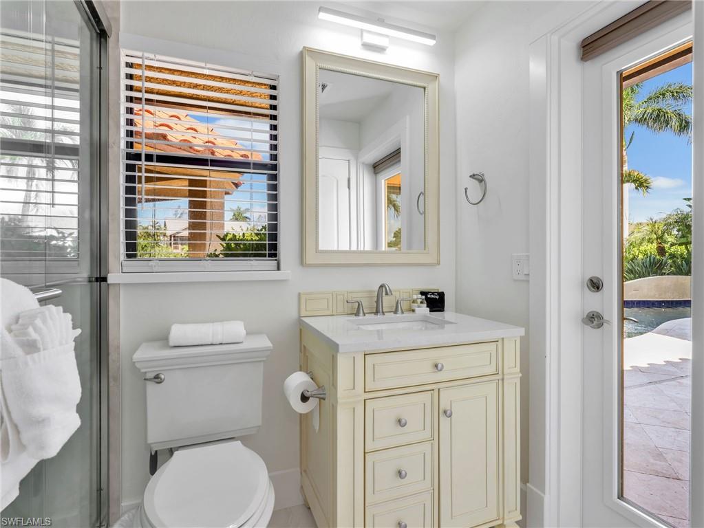 White vanity with a light countertop, integrated sink, and brushed nickel fixtures