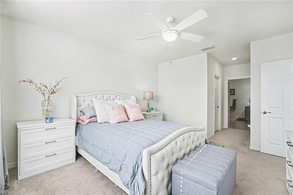 Recessed lighting, ceiling fan with integrated light, carpeted flooring, and a panel door with dark hardware