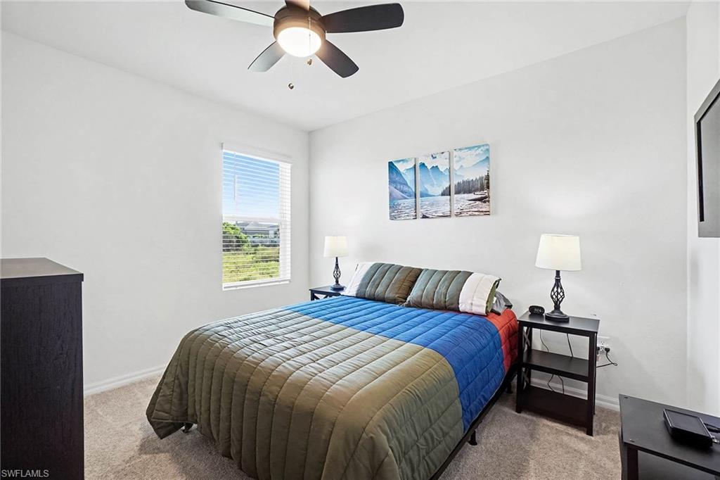 Recessed window with blinds, ceiling fan with integrated lighting, and neutral carpet flooring