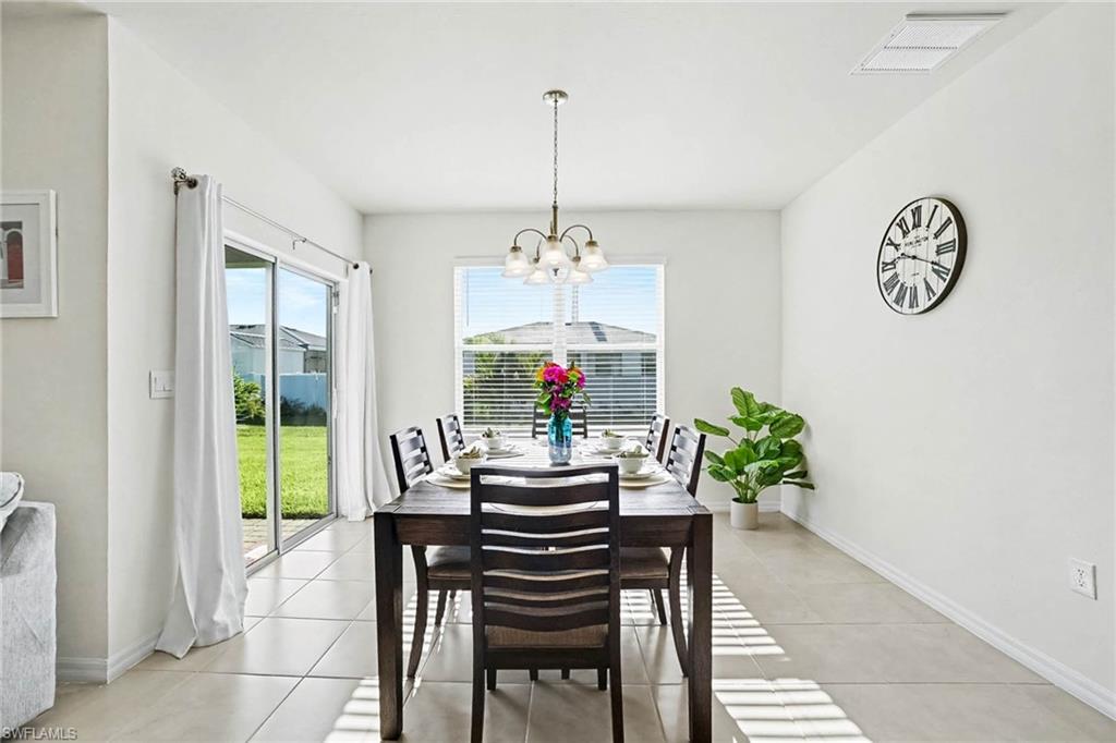 Bright interior with light-toned tile flooring, featuring a window and sliding glass door