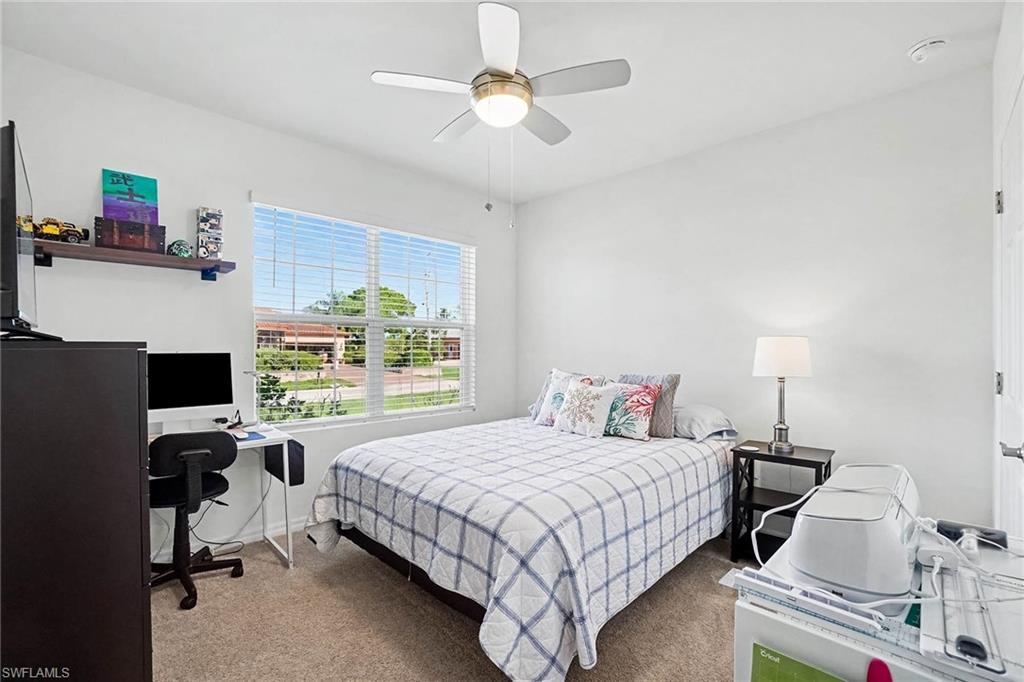 Bright interior with neutral wall colors, carpeted flooring, and a ceiling fan with integrated lighting