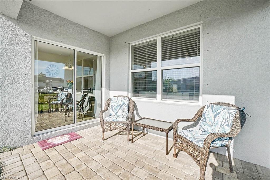 Covered patio featuring a paver floor and textured exterior walls