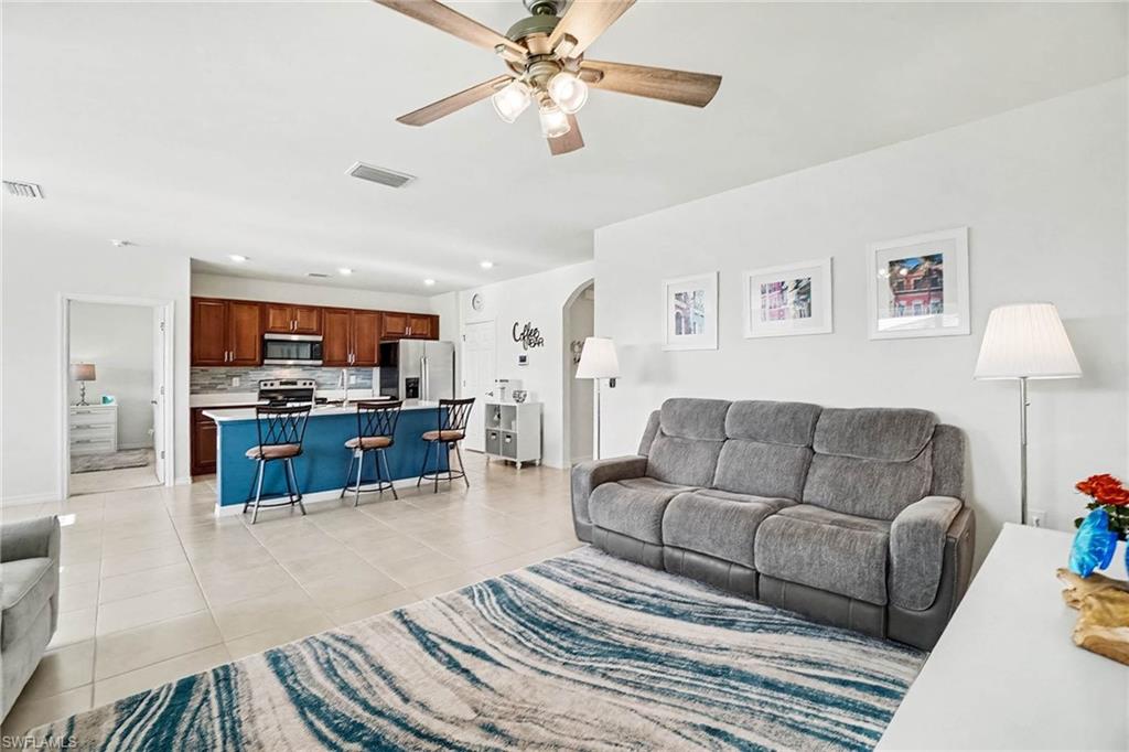 Open-concept living area with tile flooring and a ceiling fan