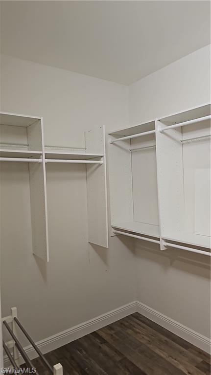 Built-in white shelving with hanging rods and wood-finish flooring