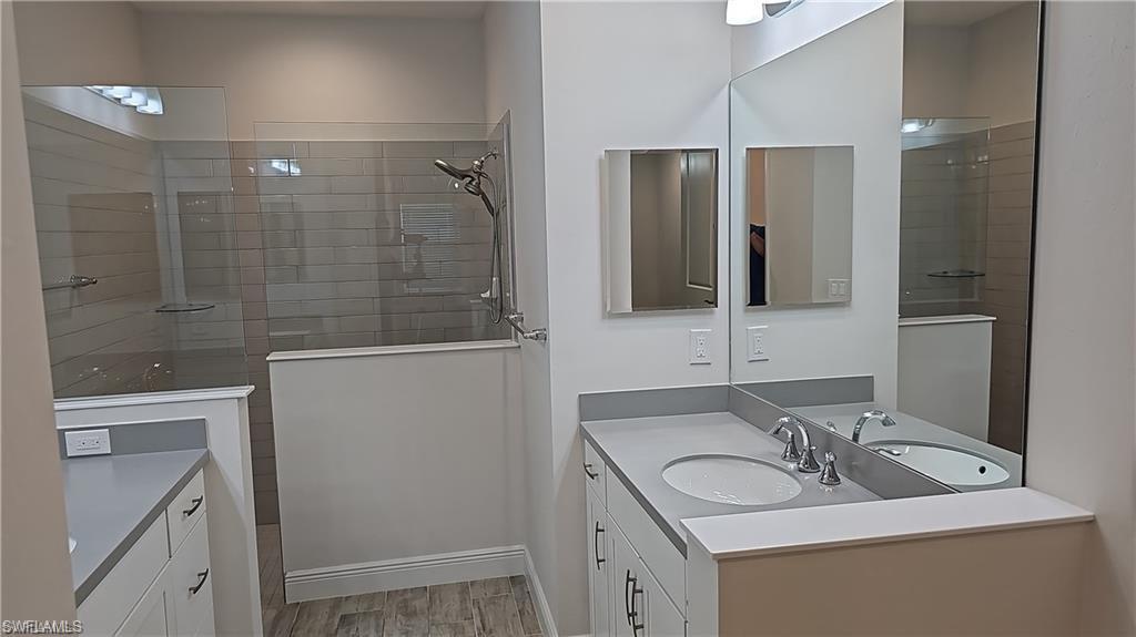Dual vanity with undermount sinks, single-handle faucets, and light gray countertops