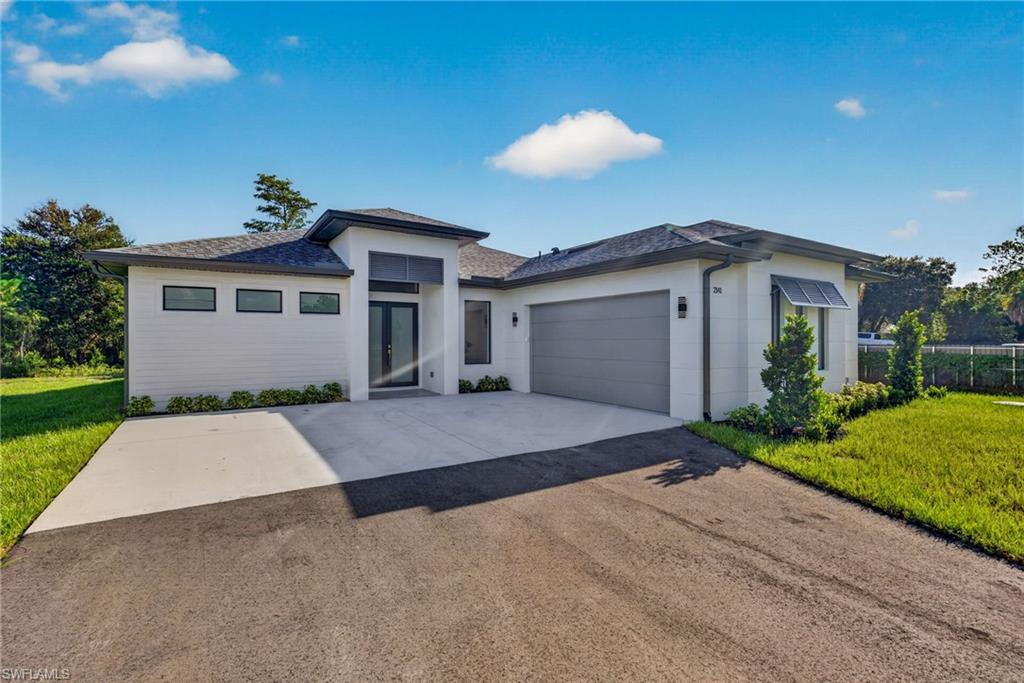 Contemporary single-story residence with a dark asphalt shingle roof, a two-car garage, and a concrete driveway
