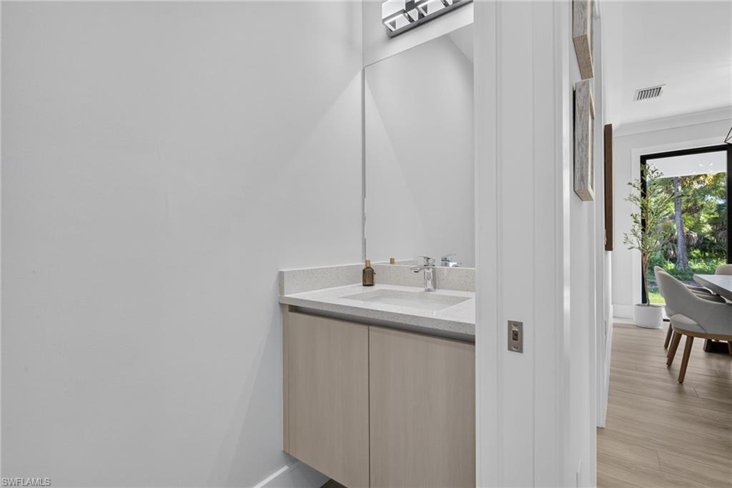 Floating vanity with a light-toned wood-finish cabinet, integrated basin, and chrome faucet