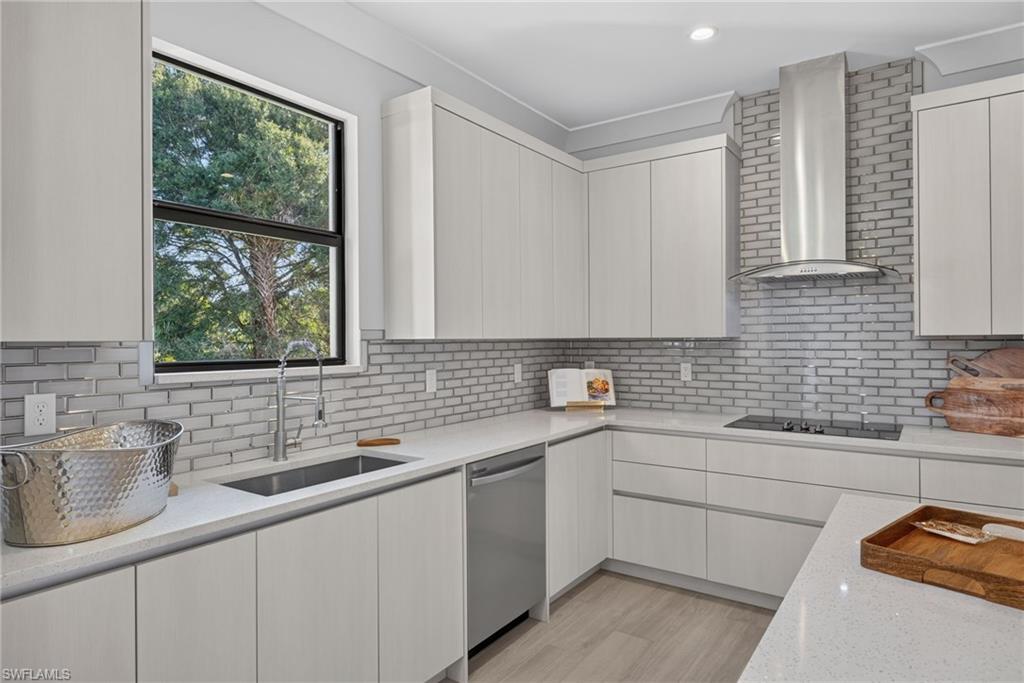 Modern kitchen featuring light-toned cabinetry, stainless steel appliances, a subway tile backsplash, and light-toned countertops