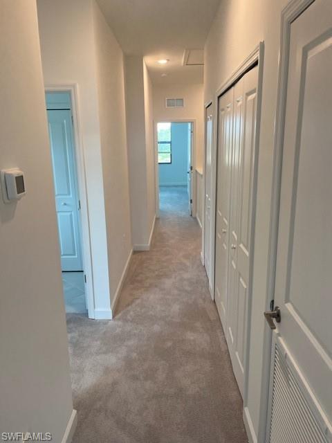 Hallway featuring carpet floors and baseboards