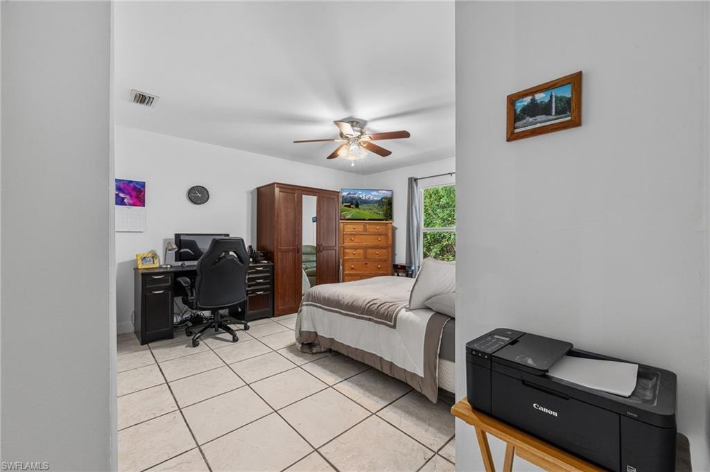 Tile flooring, white walls, and a ceiling fan with light fixture