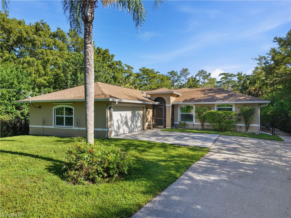 Stucco exterior with an attached garage, arched entry, and concrete driveway