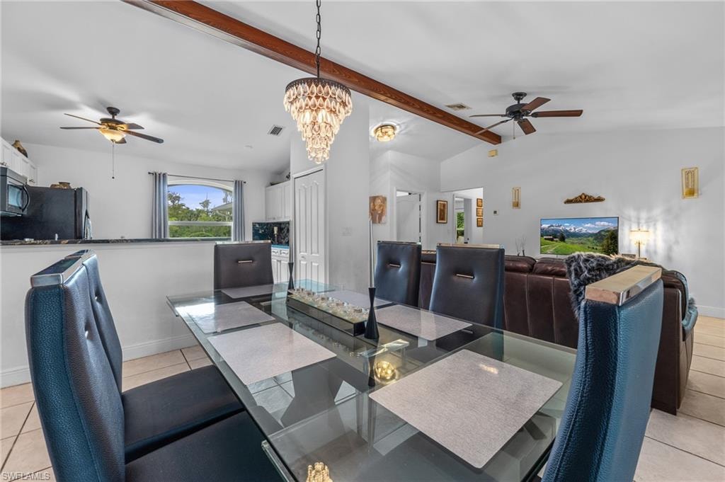 Open-concept living area featuring a vaulted ceiling with exposed wood beams, a crystal chandelier, and ceiling fans