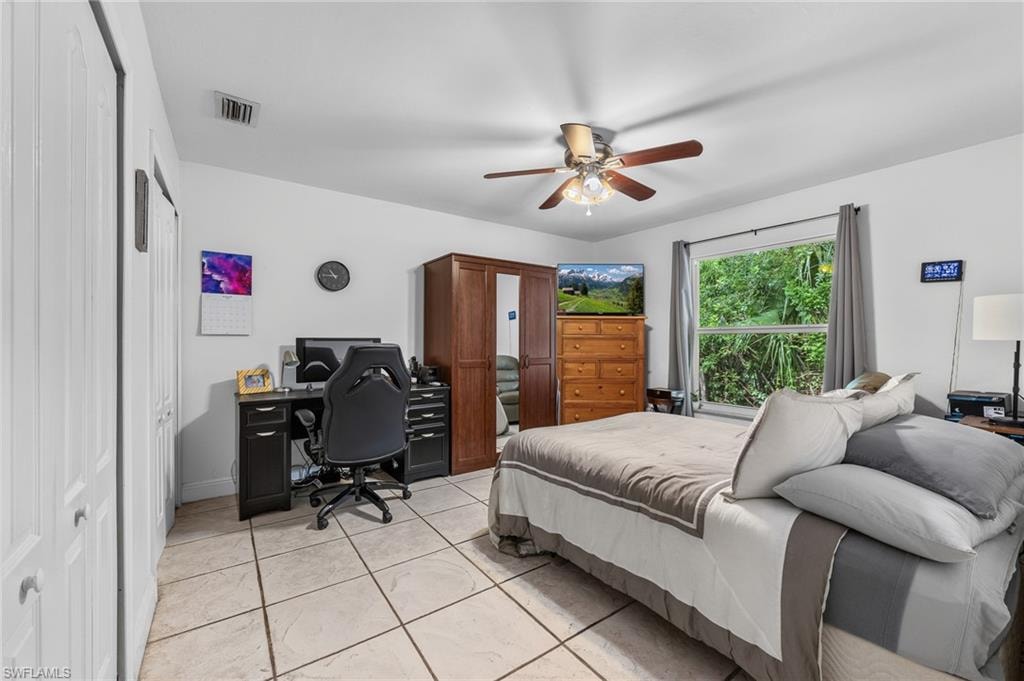 Recessed lighting, ceiling fan with light fixture, large window with natural scenery, and neutral-toned tile flooring