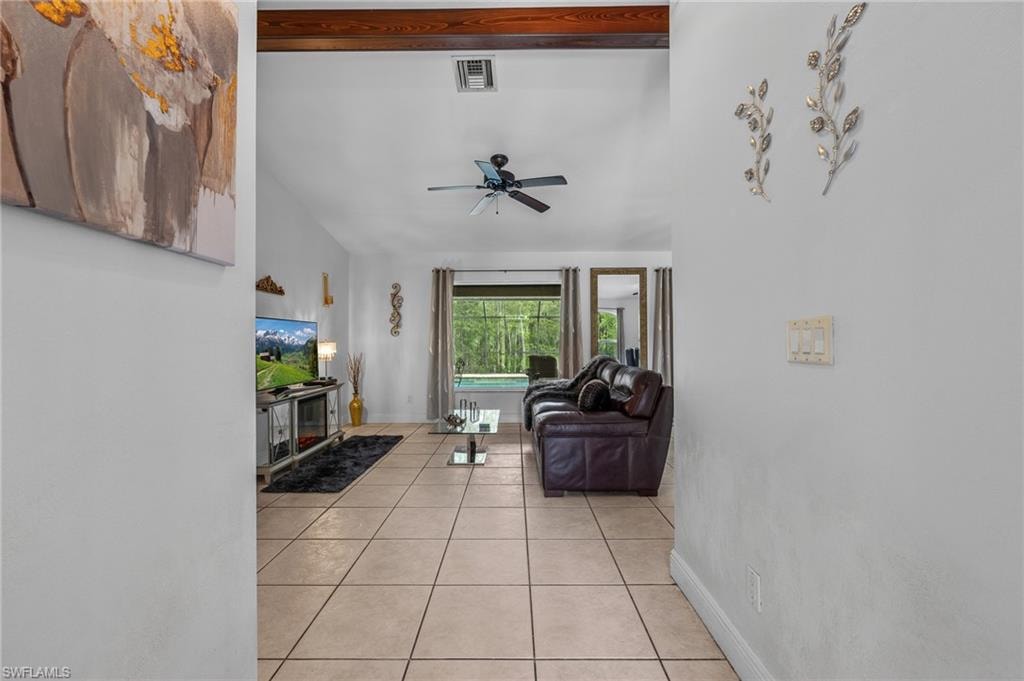 Tile flooring, vaulted ceiling, exposed wood beam, ceiling fan, large windows