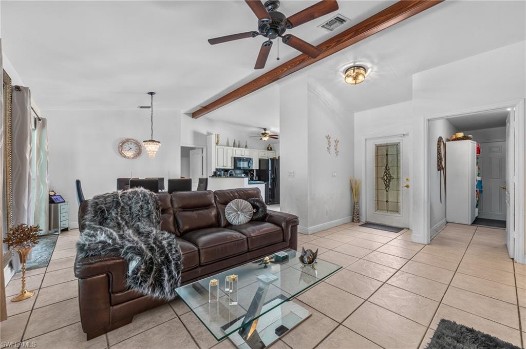 Open-concept living area featuring tile flooring, exposed beam ceiling detail, and ceiling fan with integrated lighting