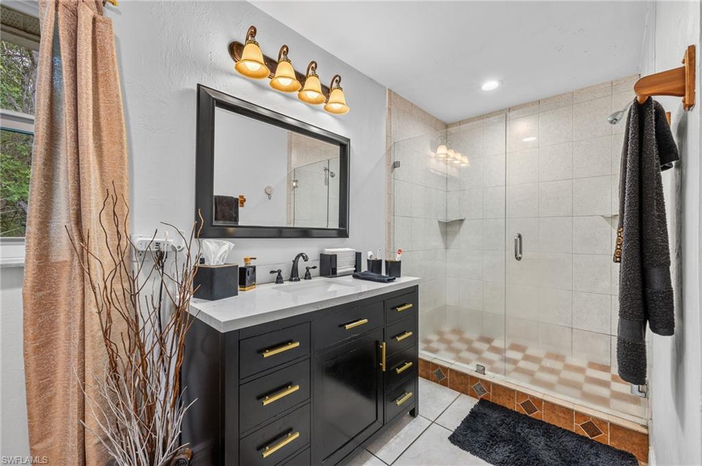 Black vanity with a white countertop and gold-toned hardware