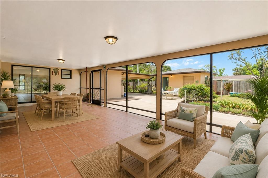 VIRTUAL Tiled flooring throughout, expansive glass panel walls, dual ceiling-mounted light fixtures, sliding glass doors, and direct outdoor access