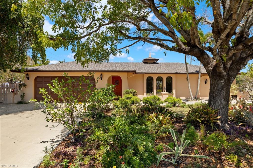 Stucco exterior with arched windows, an attached two-car garage, and a cupola roof accent
