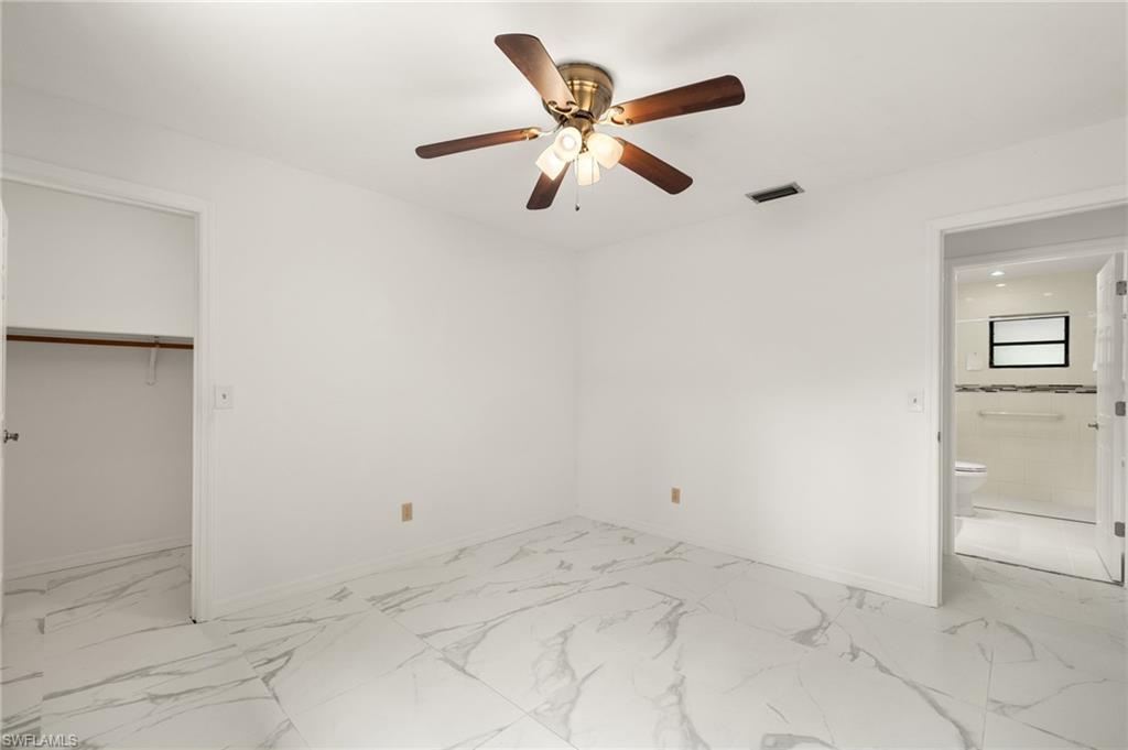 White walls with wood-finish ceiling fan and integrated lighting, complemented by white large-format tile flooring