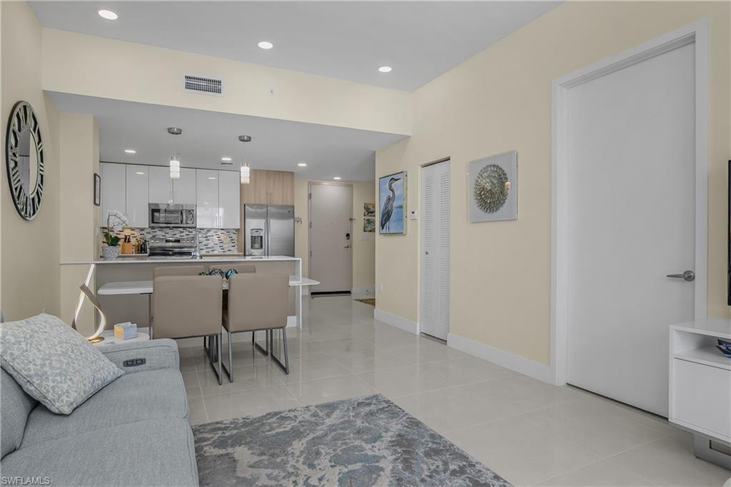 Open-concept living area with tile flooring and recessed lighting