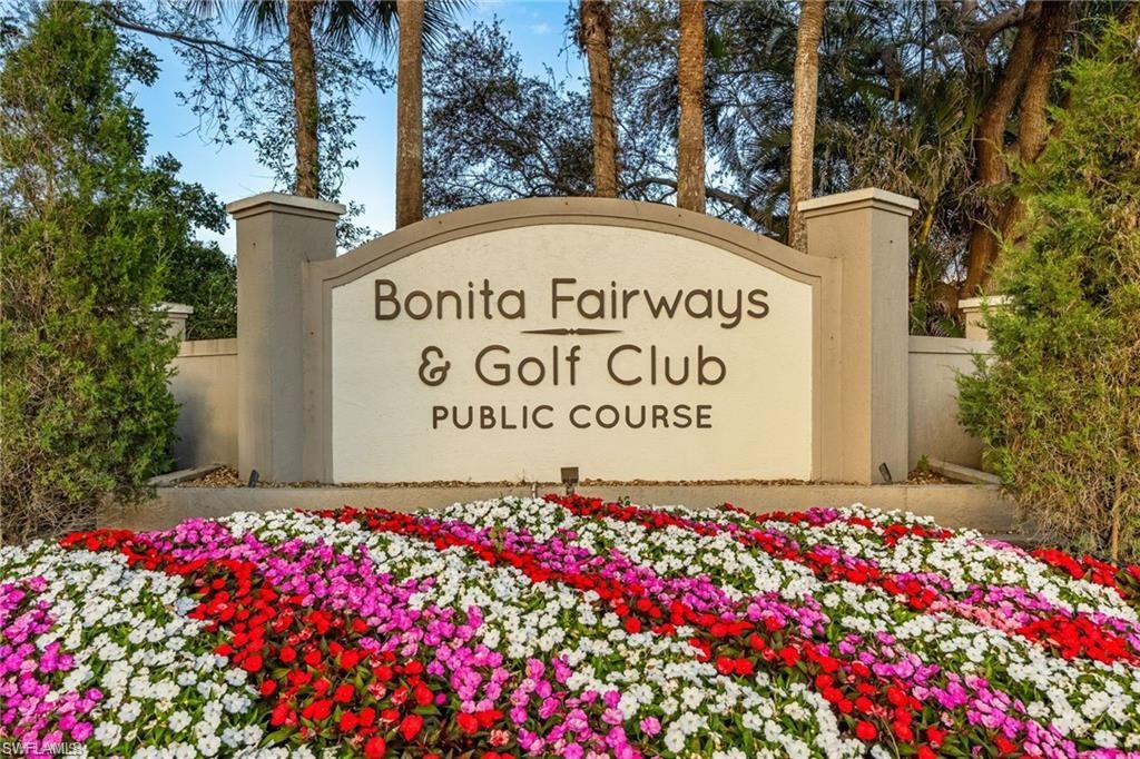 "Bonita Fairways & Golf Club" signage with manicured floral landscaping and mature palm trees
