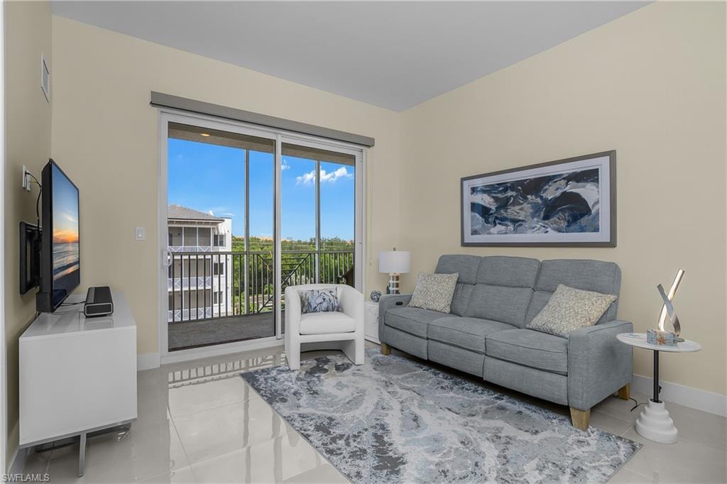 White floor tiles, a sliding glass door, and a black metal balcony railing