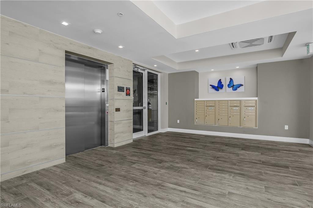 Wood-finish flooring, recessed lighting, drop ceiling, and stainless steel elevator