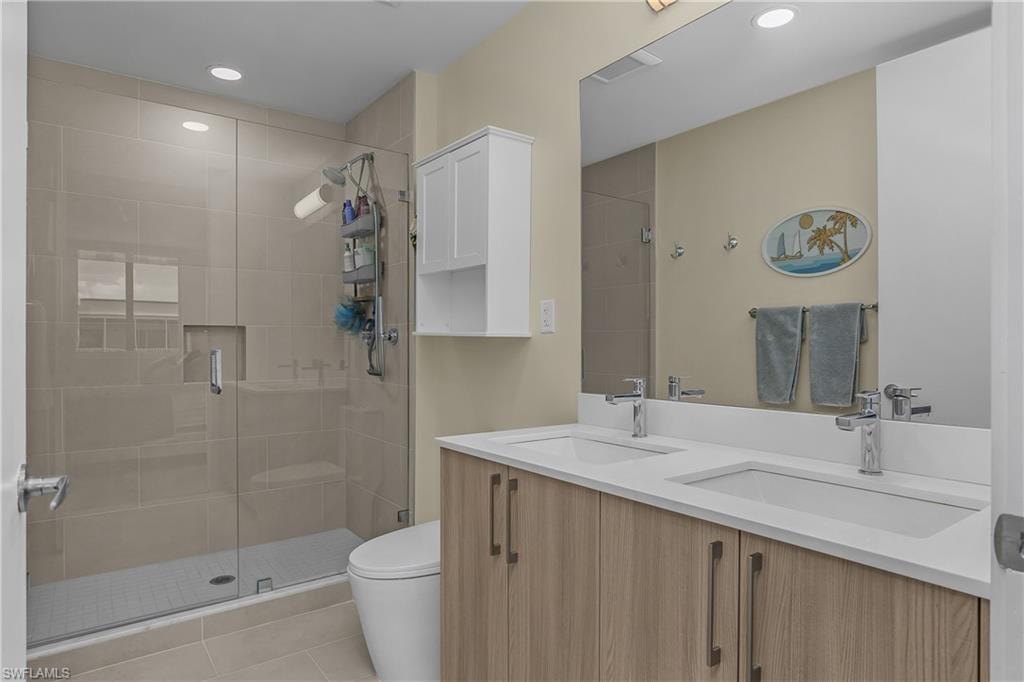 Glass-enclosed shower with a recessed shelf, dual shower heads, and an integrated bench