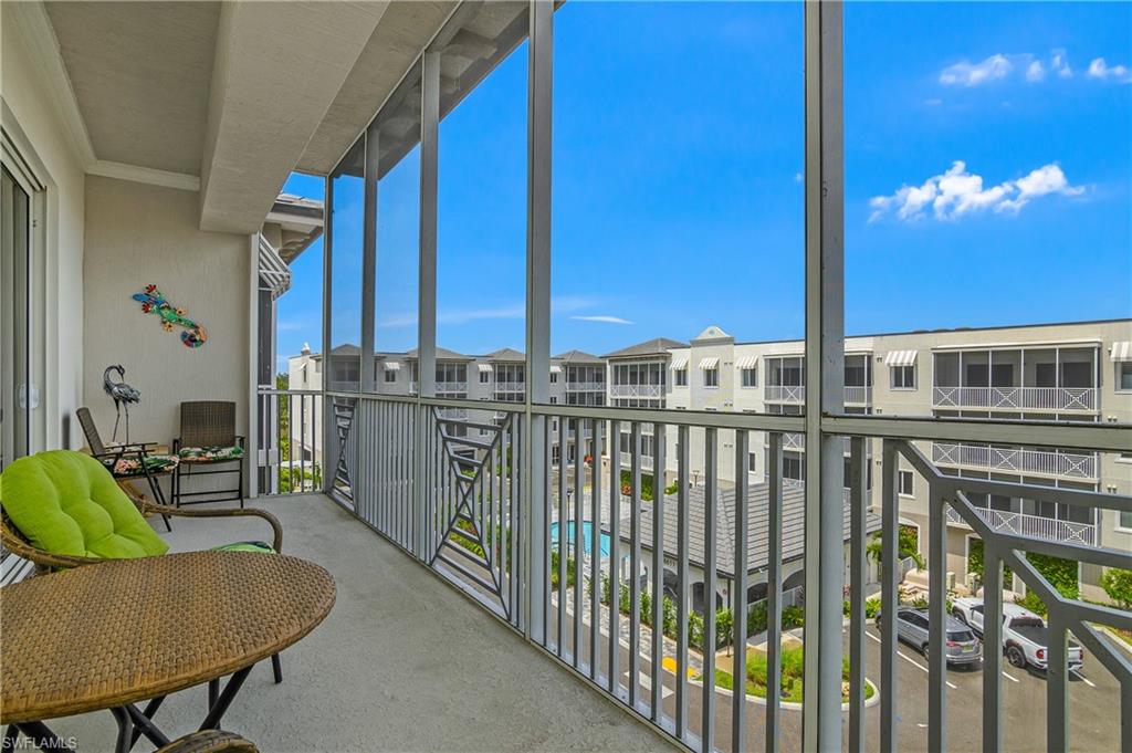 Screened balcony with concrete flooring, aluminum railings, and a sliding glass door