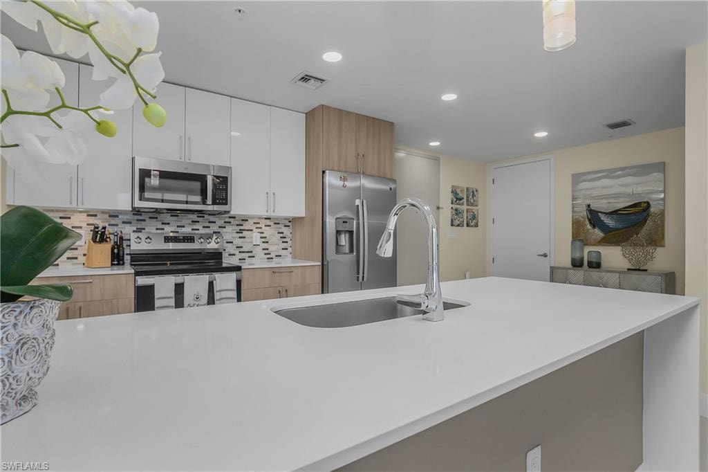 Kitchen island with an undermount sink and chrome gooseneck faucet
