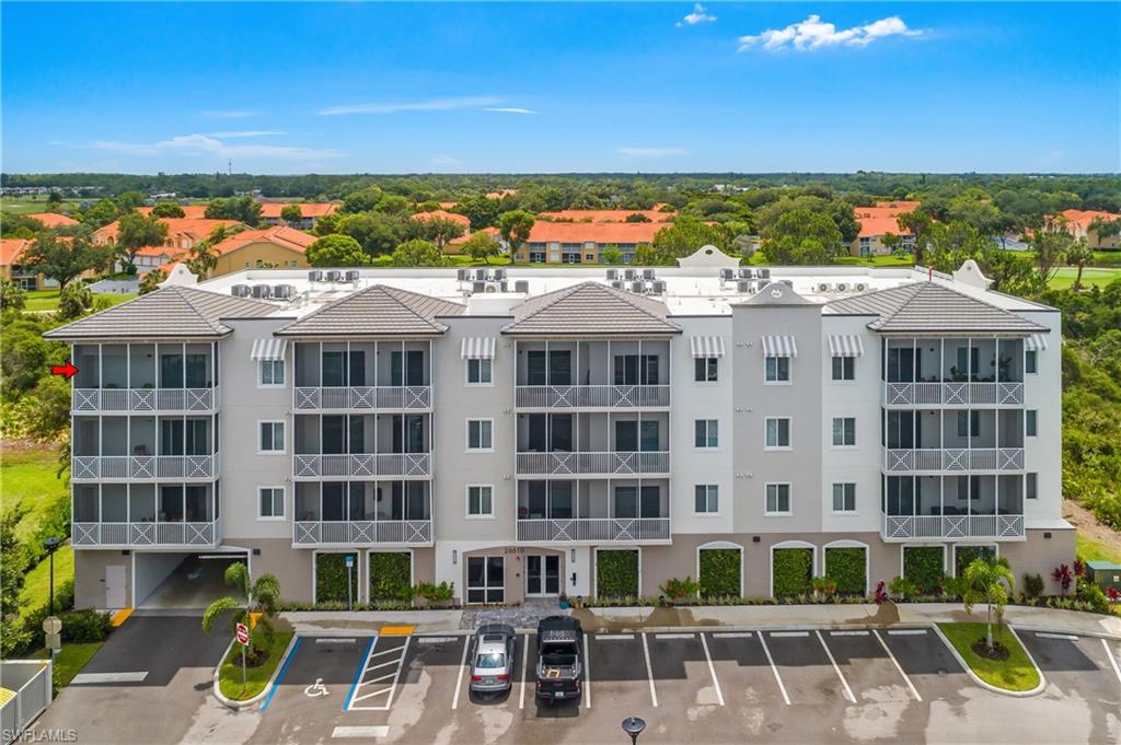 Modern multi-story structure with a tiled roof, screened balconies, and striped awnings