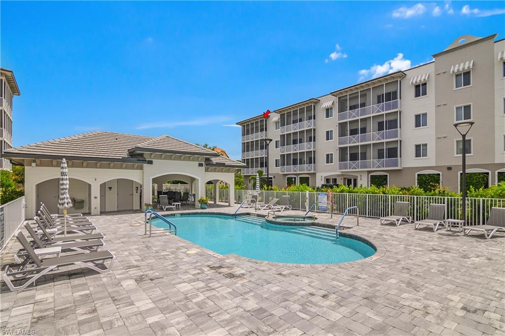 Resort-style pool with integrated spa, expansive paver deck, and covered cabana