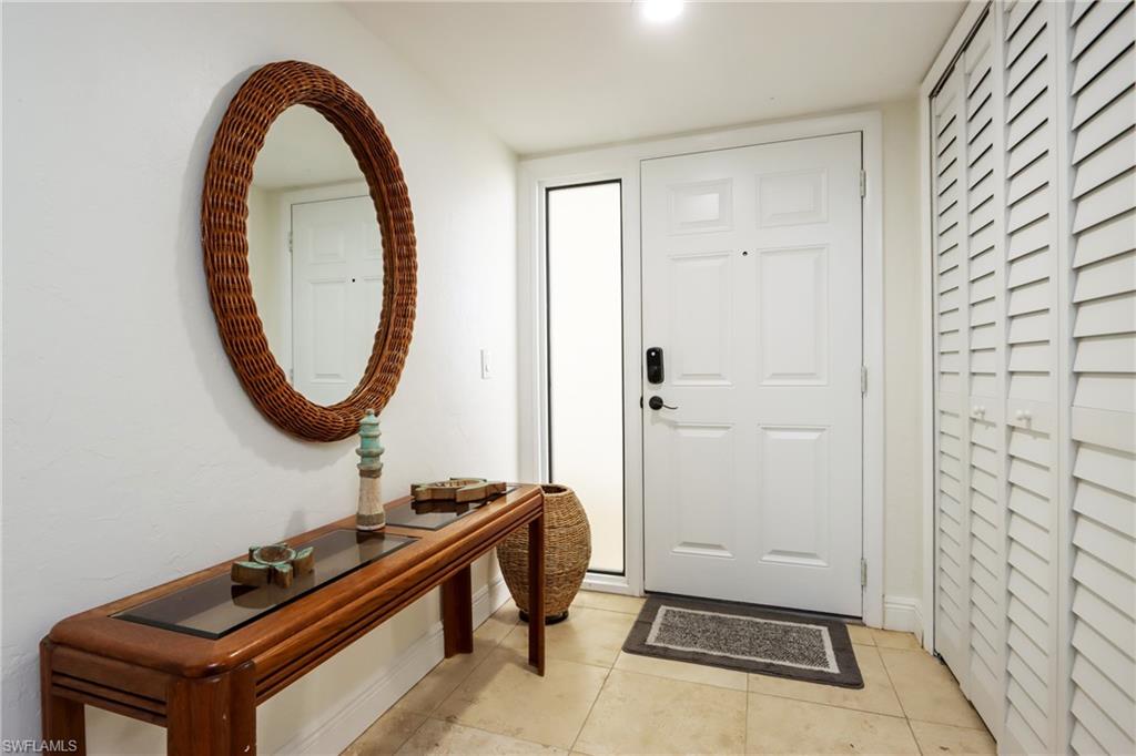 Foyer entrance with baseboards and light tile patterned flooring