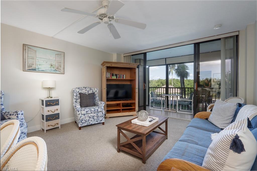 Living room with carpet, baseboards, and ceiling fan