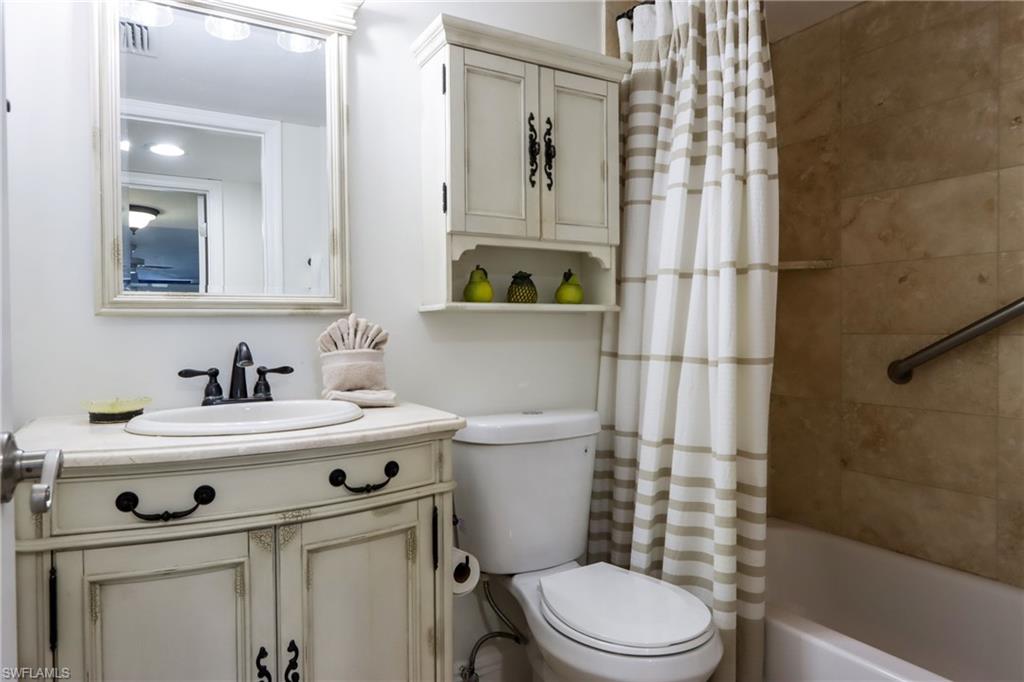 Bathroom with toilet, vanity, and shower / bath combo